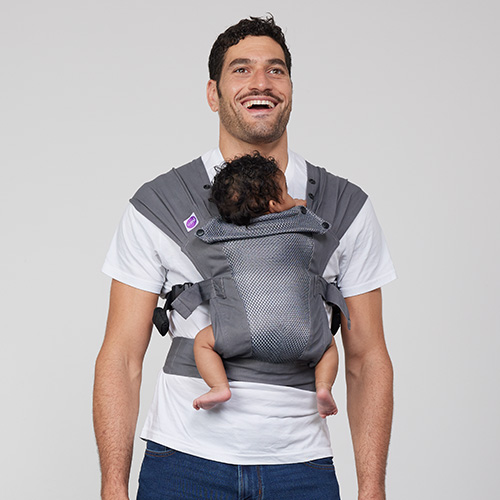 Man carries baby on his chest in Izmi Breeze Baby Carrier