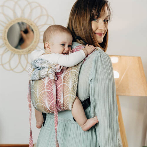 Woman carries baby on her back in Lenny Lamb Onbuhimo carrier in colourful Deco Vineyard fabric